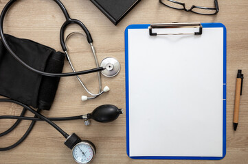 Medical stethoscope and sphygmomanometer on wooden background
