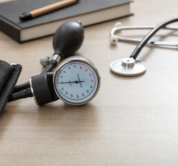 Medical stethoscope and sphygmomanometer on wooden background