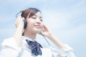 ヘッドホンで音楽を聴く女子高校生
