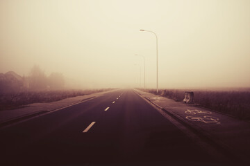 Straight road on misty dark morning.