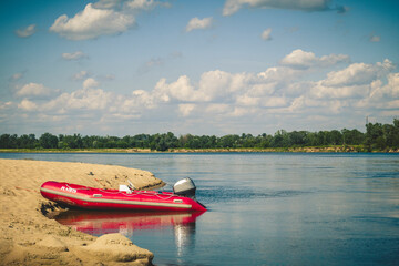 A pontoon moored on the beach by the river.