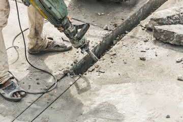 Construction worker using jackhammer drilling concrete surface