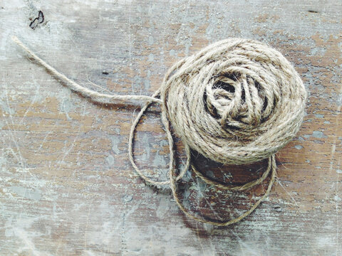 A Spool Of Twine Or Yarn On A Wooden Table