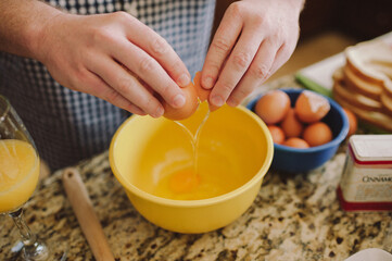 Man cracking egg into bowl