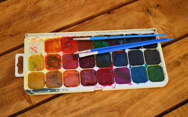 Multicolored watercolor paints and brushes. Art, drawing, school.