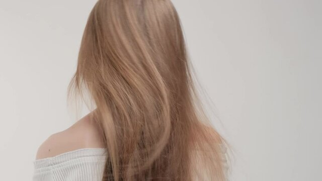 Girl with beautiful hair hair in the studio on a white background close-up.