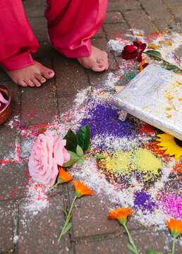 Mother of the groom jumps over the Rangoli during a sikh wedding
