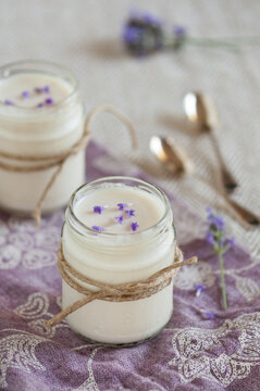 a glass jar with white yogurt and lavender flowers