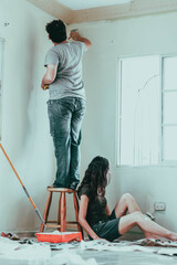 Pareja recién casada recibiendo y pintando su nuevo hogar.