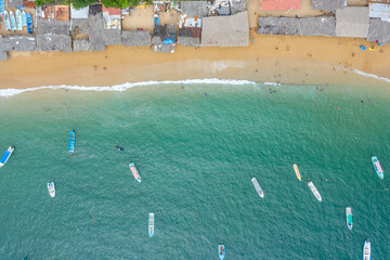 Fototapeta na wymiar Vista aérea cenital sobre la playa de la bahía de Puerto Marqués en Acapulco, Guerrero. Se observa los tradicionales techos de palma de los comercios y algunas barcas sobre el mar.