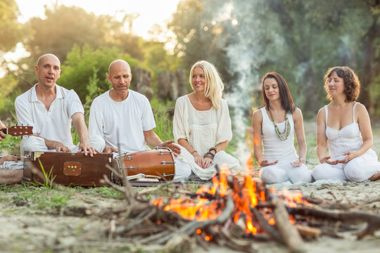 People Dressed in White Singing on the Beach