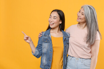 Smiling family asian female women girls mother and daughter in casual clothes posing hugging...