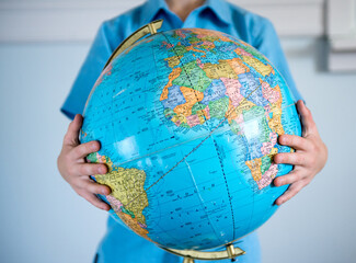 Boy holds a globe in his arms