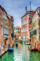 Fototapeta na wymiar Gondola Passing through a Canal in Venice