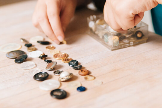hands sorting vintage buttons
