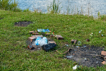 Garbage on the shore of the reservoir left by people after a picnic