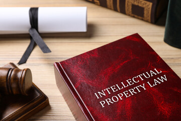 Intellectual Property law book and judge's gavel on wooden table