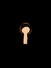 Keyhole on a black background, yellow light