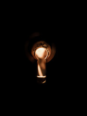 Keyhole on a dark background, yellow light