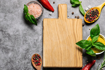 Wooden cutting board with bright aromatic herbs and spices top view. Copy space for your design. Cook book cover template.