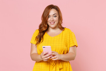 Smiling young redhead plus size body positive female woman girl 20s in yellow dress posing using...