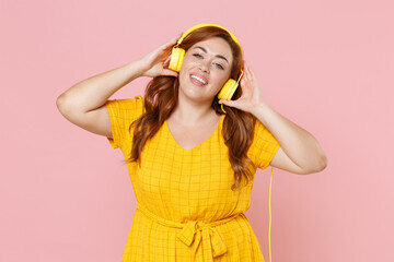Smiling young redhead plus size body positive female woman girl 20s in yellow dress posing...