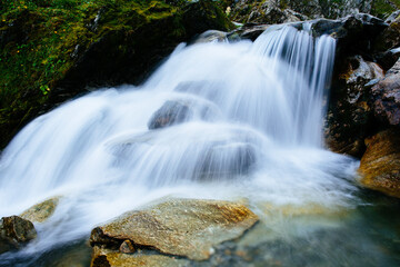 Alpine waterfall in a foggy valley