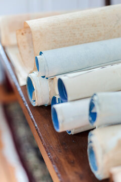 Antique scrolls lined up on a table.