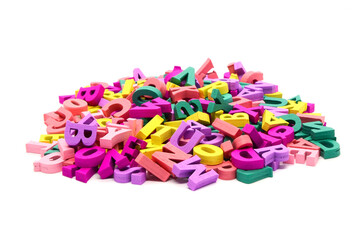 Heap of multicolored wooden letters of the Latin alphabet isolated on white background. Concept: back to school, literacy and reading, language learning.