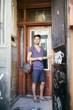 Young Man Collecting Mail in Old Apartment Building in New York