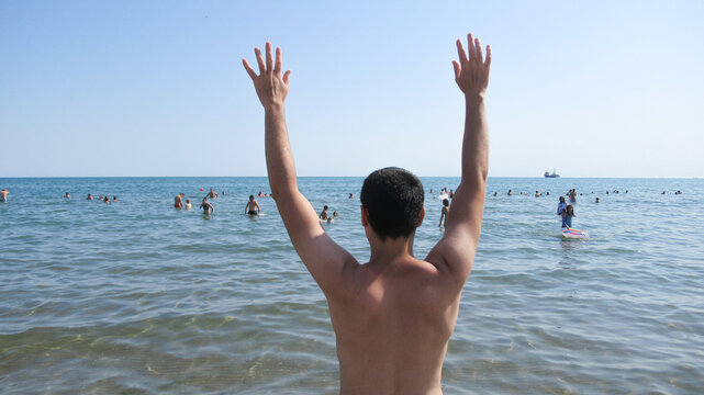 Baku, Azerbaijan, July 5 2020 : Young White Caucasian Man Waving Into The Sea To The People