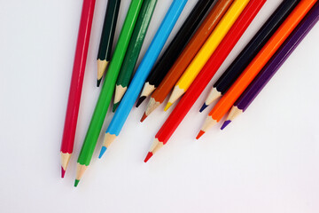 Obraz premium Colored pencils on white background. Many different colored pencils. Color pencil. Pencils are sharp. Pencils placed diagonally in the upper-right corner. Close-up. Copy space. Background. Flatlay