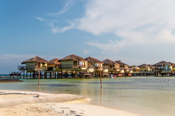 Water Villas (Bungalows) and wooden bridge at Tropical beach in the Caribbean sea