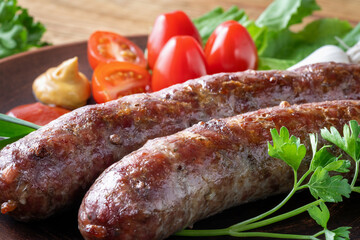 Food poster, restaurant setting - a portion of grilled sausages with tomatoes and herbs, ketchup, mustard. On a rustic table.
