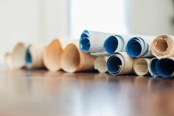 Antique maps and architectural plans rolled up on a table.