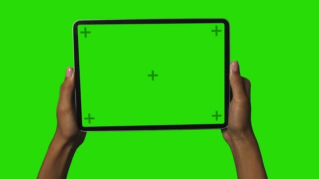 Woman Holding Tablet PC in Black female hands with trackers on the screen and Chromakey Green screen background