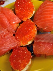 Fish and caviar sandwiches on a plate, close-up