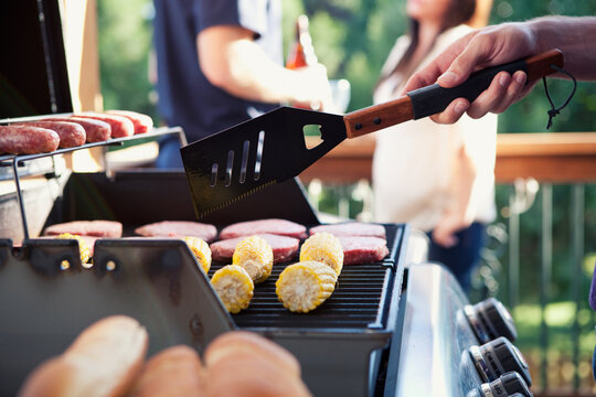 Party: Man Cooking Burgers and Corn at Party