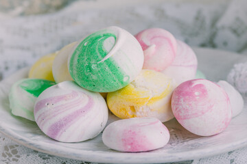 White plate with colorful little meringues