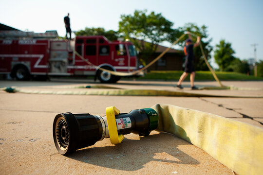 Firehouse: Firemen Resetting Fire Hose on Truck