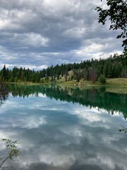 Clouds reflections in beautiful lake with trees