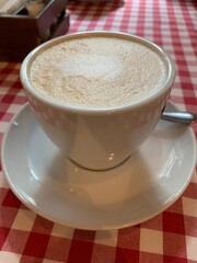 A mug of hot aromatic coffee with milk and thick foam