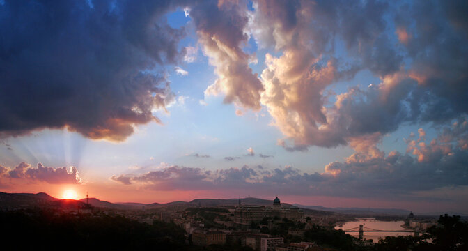Setting sun with glowing clouds above Budapest