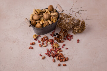 Nuts peanuts, walnuts in a metal bowl and scattered on the table. beautiful composition on the table.. still life