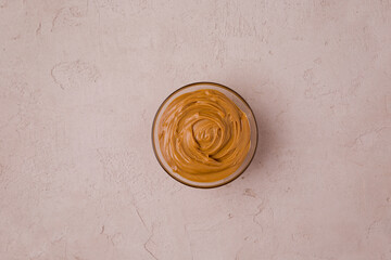 Peanut butter in a transparent cup. View from above. Copy space for your text