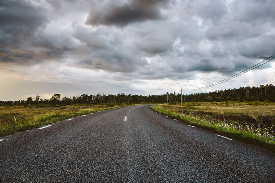 Storm clouds over empty country road