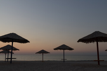 Fototapeta na wymiar Beautiful seascape with beach umbrellas. Dawn at sea. Image