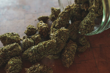 Dried Cannabis with jar and wood background  