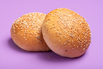 Hamburger buns isolated on a purple color. Homemade bread buns with sesame