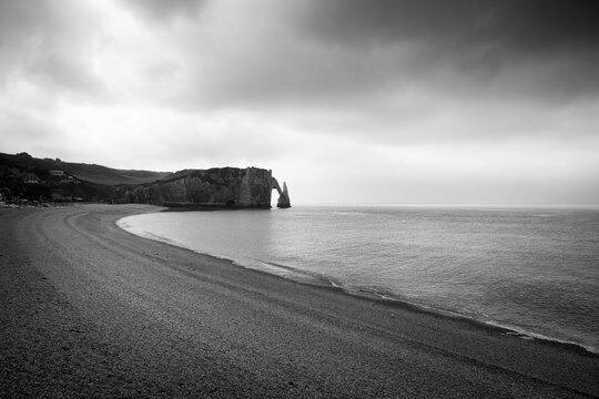 Etretat chalk cliffs in Normandy, France, on a cloudy day